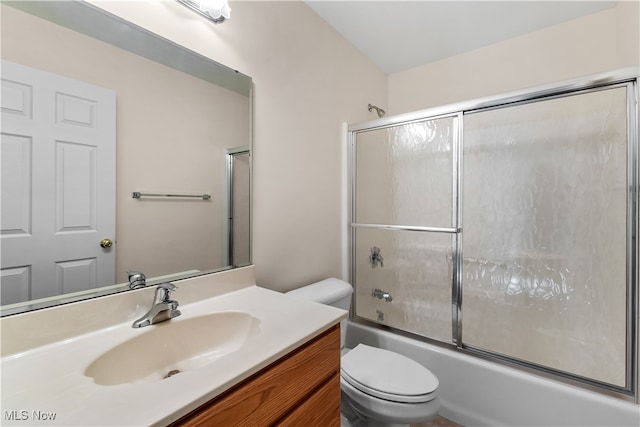 full bathroom featuring vanity, toilet, and bath / shower combo with glass door