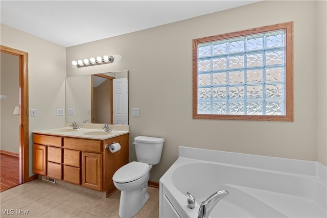 bathroom featuring tile patterned floors, a bathing tub, vanity, and toilet