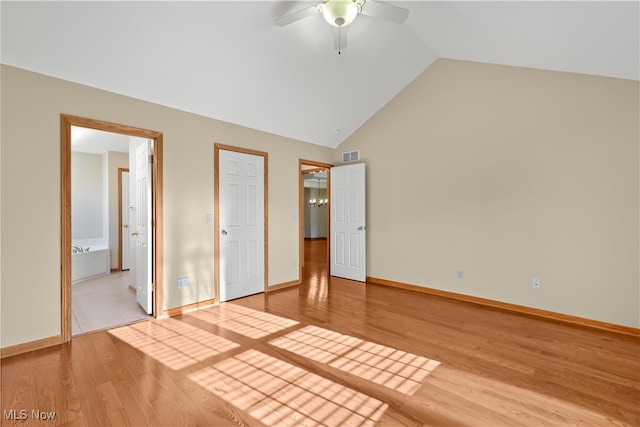 unfurnished bedroom featuring lofted ceiling, ceiling fan, light wood-type flooring, and connected bathroom