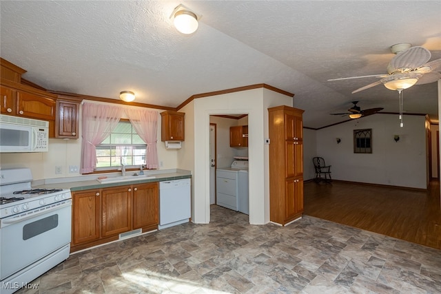 kitchen featuring sink, vaulted ceiling, washing machine and dryer, white appliances, and ceiling fan