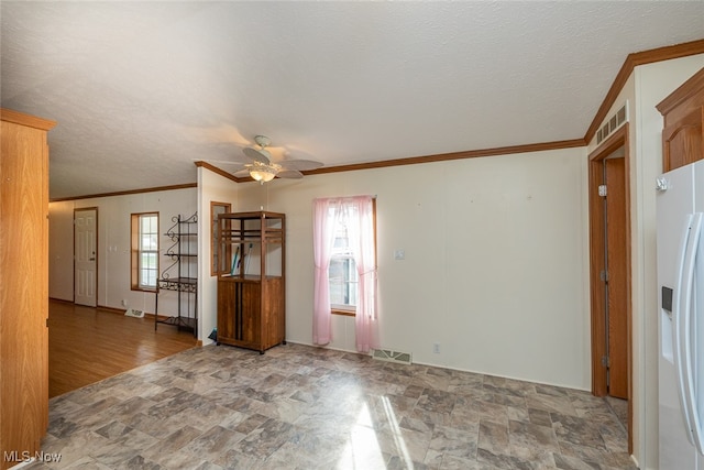 unfurnished room with ceiling fan, a textured ceiling, crown molding, and wood-type flooring