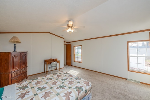 carpeted bedroom featuring crown molding, multiple windows, ceiling fan, and vaulted ceiling