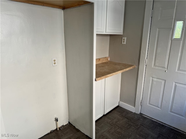 kitchen featuring dark parquet flooring and white cabinets