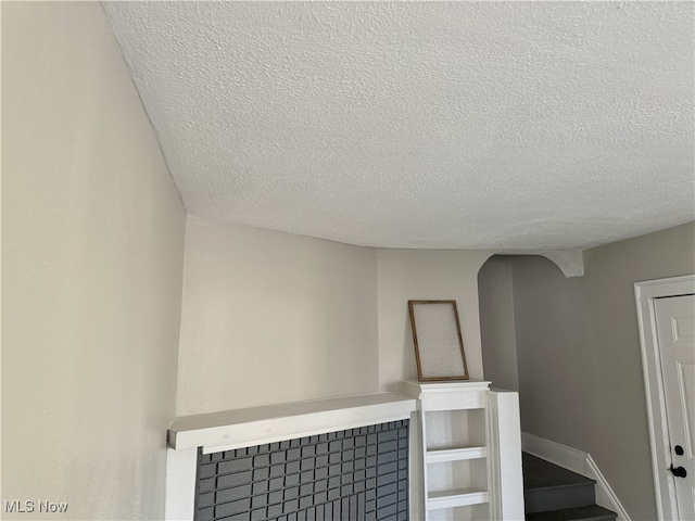 staircase featuring a textured ceiling