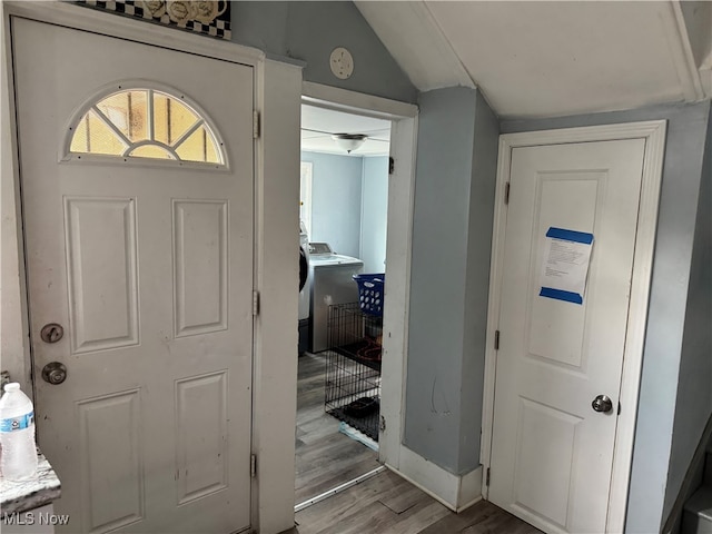 foyer entrance featuring light hardwood / wood-style floors, lofted ceiling, and washer / dryer