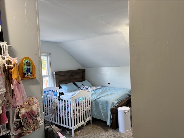 carpeted bedroom with lofted ceiling