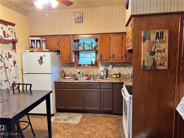 kitchen with backsplash, white appliances, sink, and ceiling fan