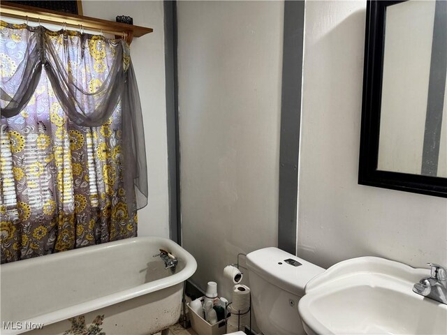 bathroom featuring a bathing tub, sink, and toilet