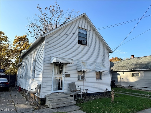 view of front facade with a front yard and cooling unit