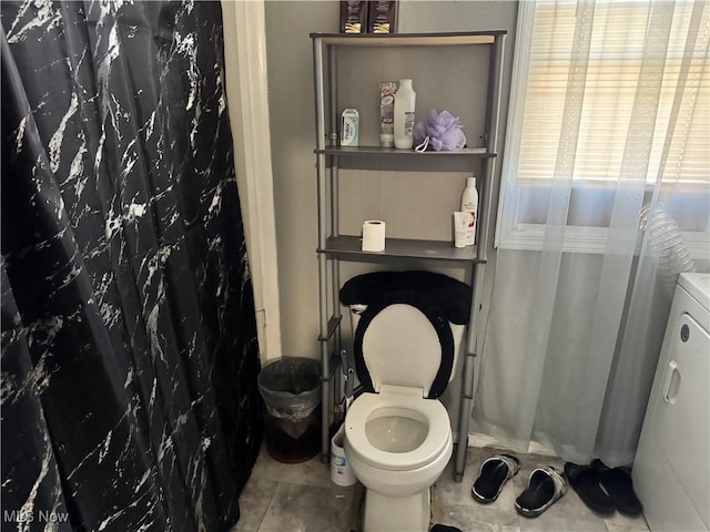 bathroom with tile patterned flooring, toilet, and a shower with shower curtain