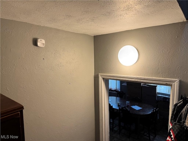 interior details with a textured ceiling and a textured wall