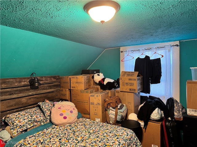 bedroom featuring a textured ceiling and vaulted ceiling