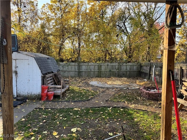 view of yard with an outdoor structure, a fenced backyard, and a shed