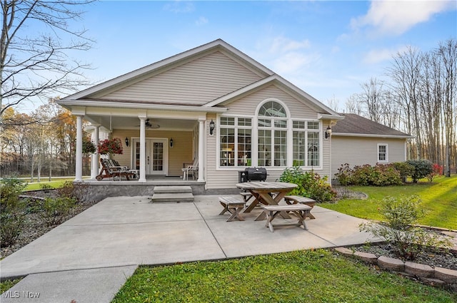 rear view of property with a porch, a lawn, and ceiling fan