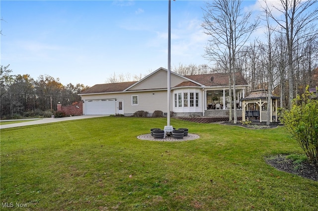 back of house featuring a garage and a lawn