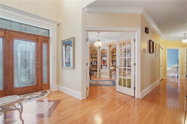 foyer entrance featuring hardwood / wood-style floors and crown molding