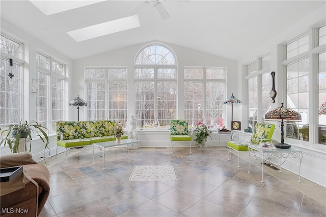 unfurnished sunroom with ceiling fan and vaulted ceiling with skylight