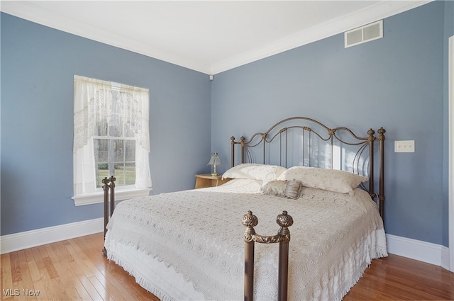 bedroom featuring hardwood / wood-style floors and crown molding