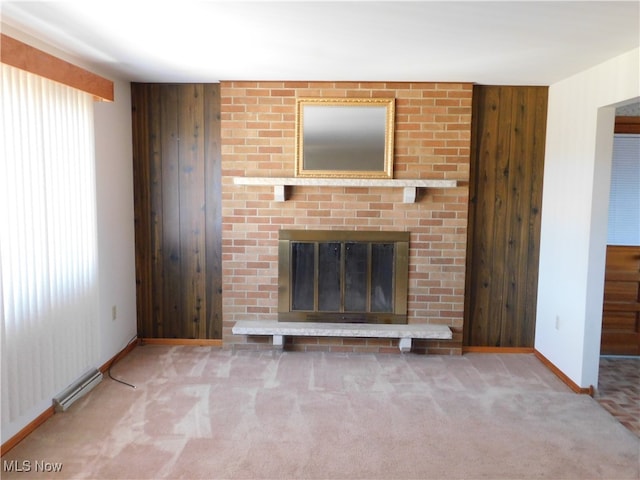 unfurnished living room with wood walls, carpet floors, and a brick fireplace