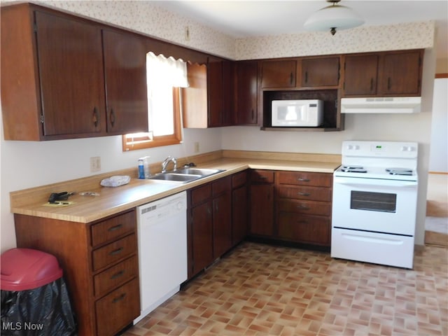 kitchen with white appliances, sink, and dark brown cabinetry