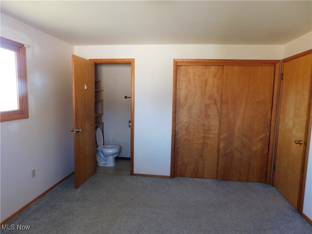 bedroom with ensuite bathroom, carpet, and a closet