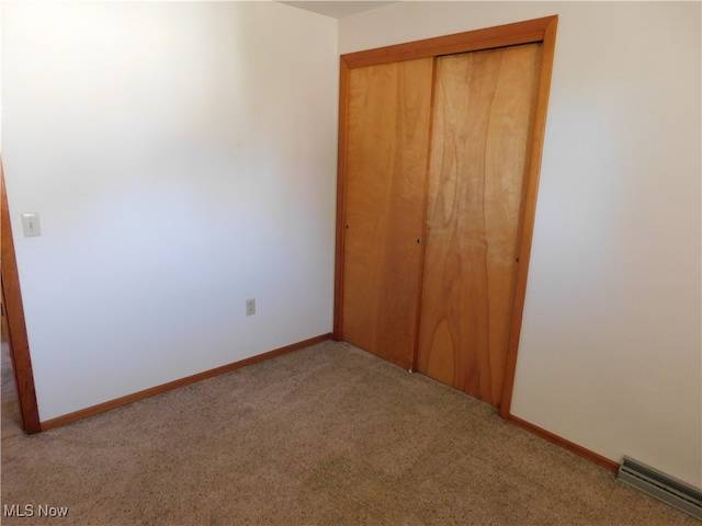 unfurnished bedroom with light carpet and a closet