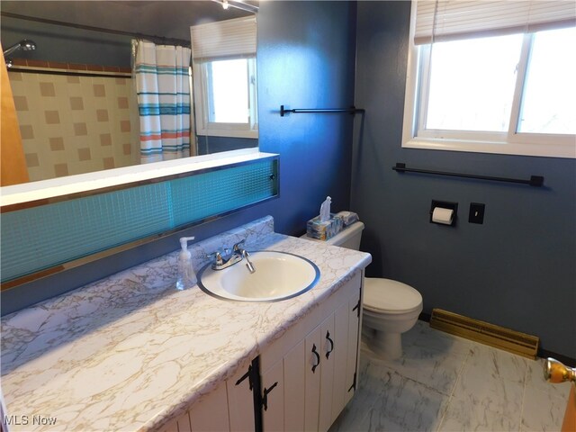 bathroom with toilet, vanity, and walk in shower