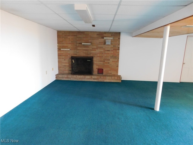 basement with a drop ceiling, a fireplace, and carpet floors