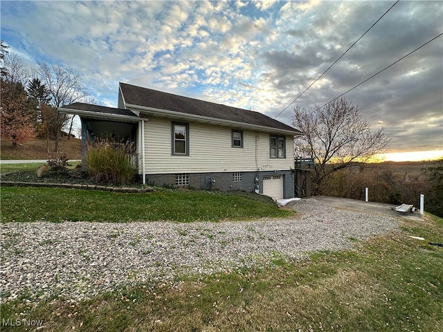 property exterior at dusk with a garage and a lawn