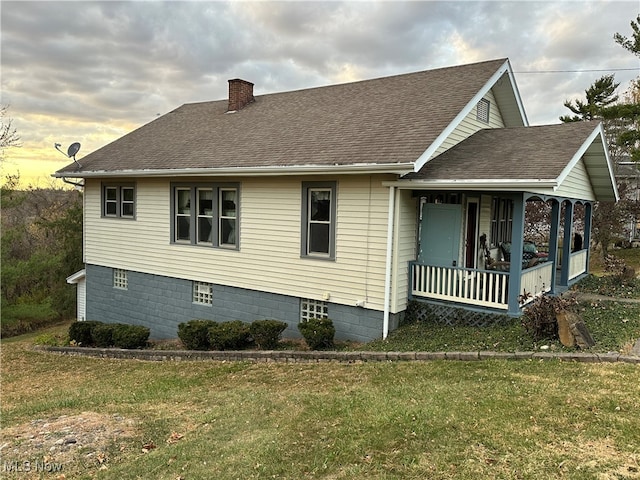 view of home's exterior featuring a lawn and covered porch