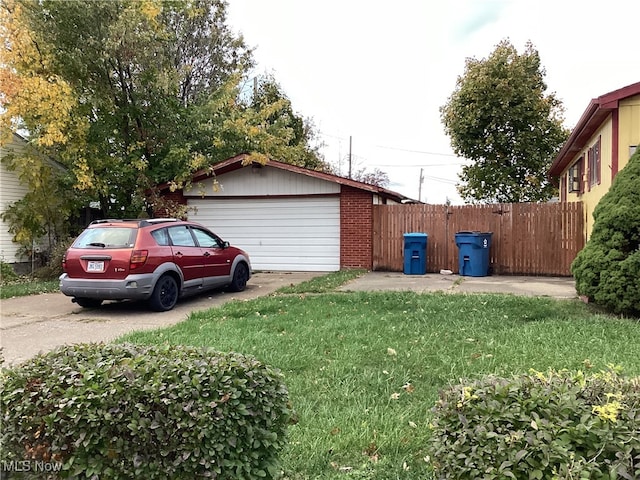 view of side of property featuring a garage and a lawn