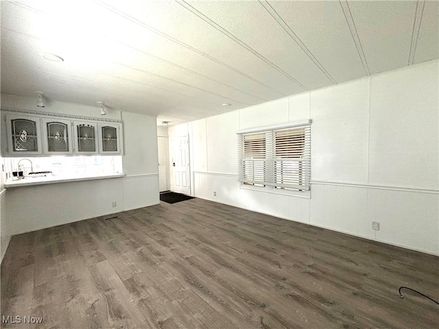 unfurnished living room featuring dark hardwood / wood-style floors and sink