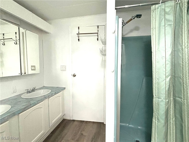 bathroom featuring walk in shower, vanity, and hardwood / wood-style floors