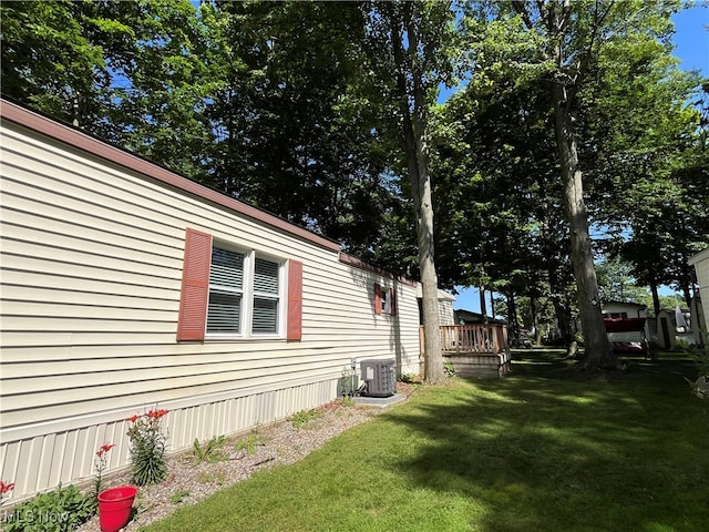 view of home's exterior with a deck, cooling unit, and a yard