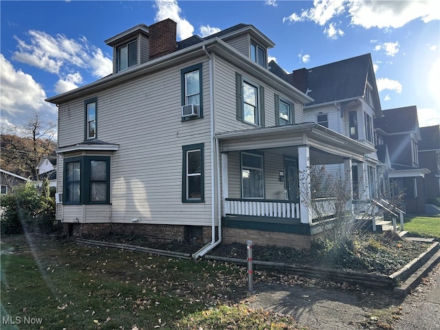 view of side of home with cooling unit and a porch