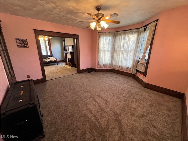 unfurnished dining area with carpet and ceiling fan