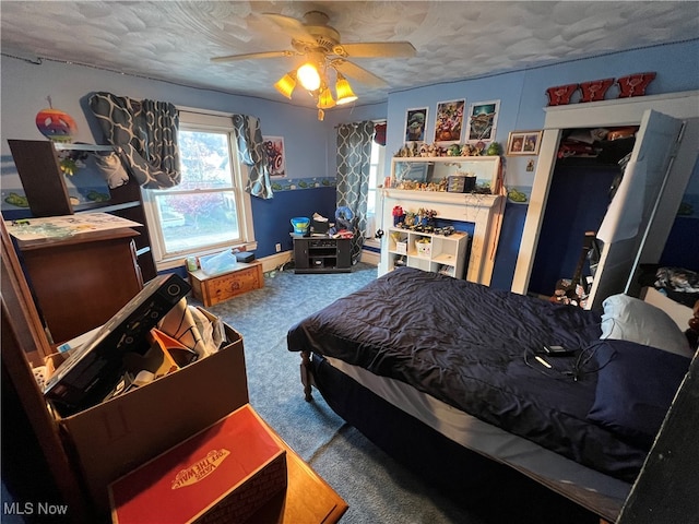 bedroom with ceiling fan, a textured ceiling, and carpet