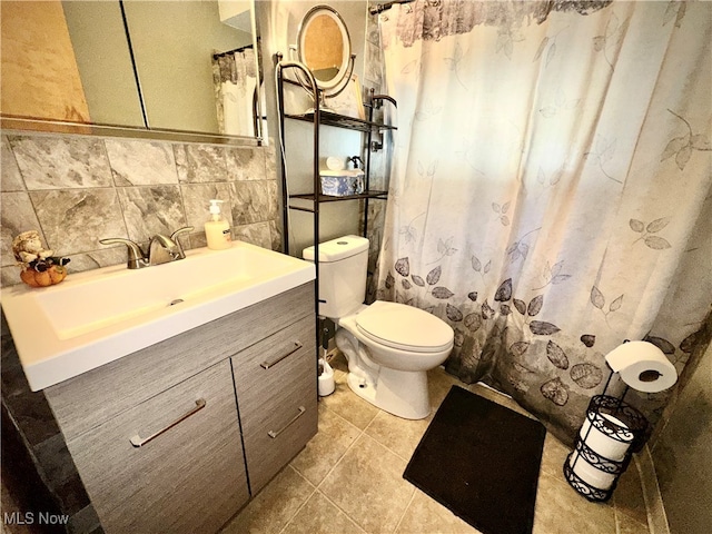 bathroom with tile patterned flooring, backsplash, tile walls, vanity, and toilet