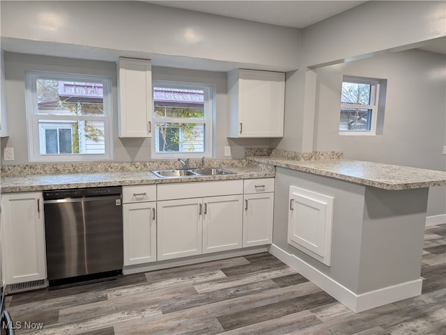 kitchen with stainless steel dishwasher, plenty of natural light, kitchen peninsula, and sink