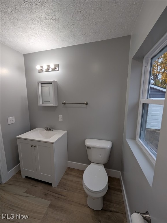 bathroom with hardwood / wood-style floors, vanity, and a textured ceiling