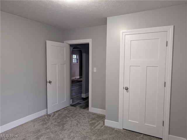 unfurnished bedroom with light carpet and a textured ceiling