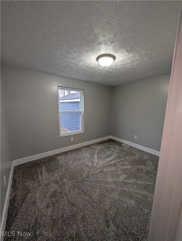 empty room featuring carpet and a textured ceiling