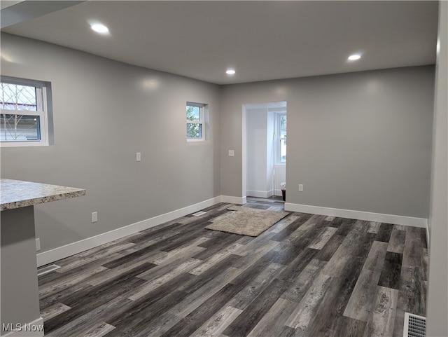 unfurnished room featuring plenty of natural light and dark hardwood / wood-style floors