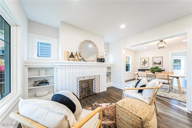 living room featuring dark wood finished floors, a brick fireplace, recessed lighting, and baseboards