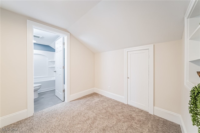 additional living space with light carpet and vaulted ceiling