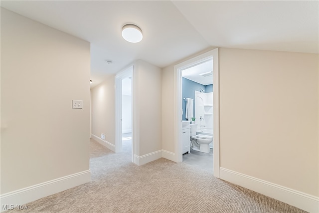 corridor featuring lofted ceiling and light carpet