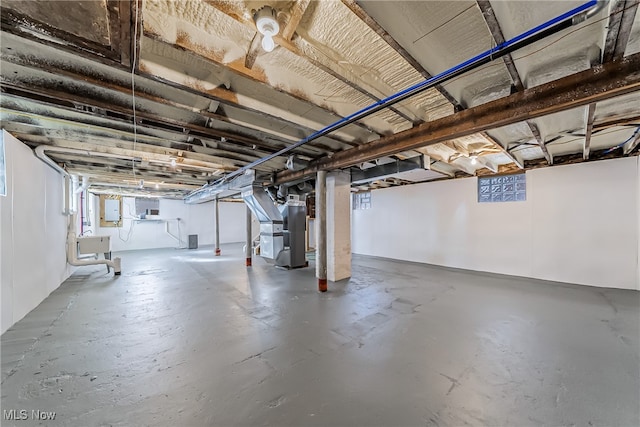 basement with electric panel, sink, and heating unit