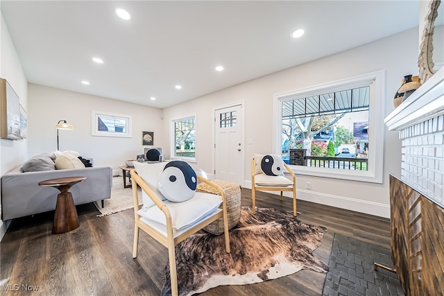 living area with dark wood-type flooring, recessed lighting, and baseboards