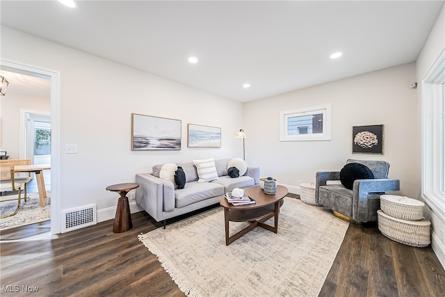 living area featuring dark wood-type flooring, recessed lighting, visible vents, and baseboards