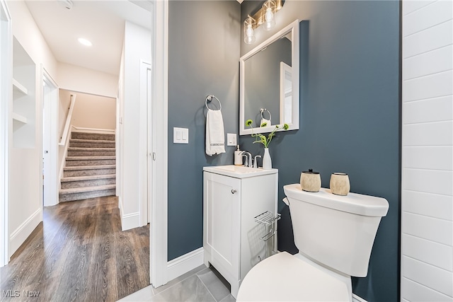 bathroom with hardwood / wood-style flooring, vanity, and toilet